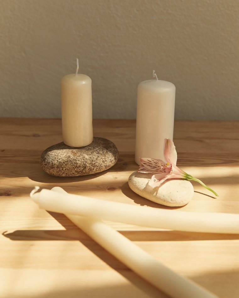 Candles and river stones in warm afternoon light